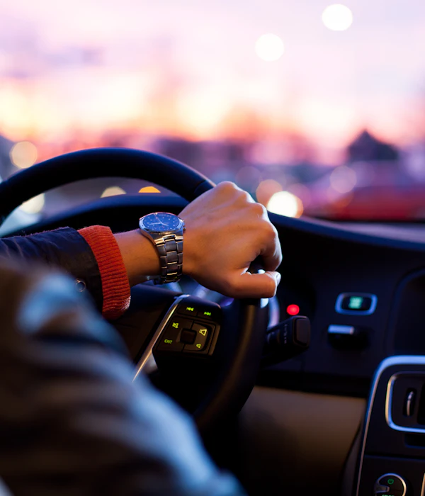A driver’s hand on the steering wheel