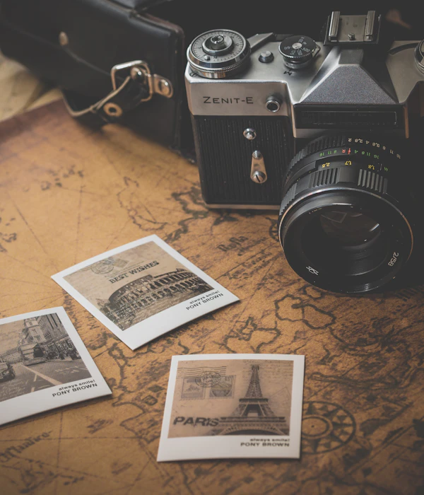 A vintage camera and printed photographs on a map